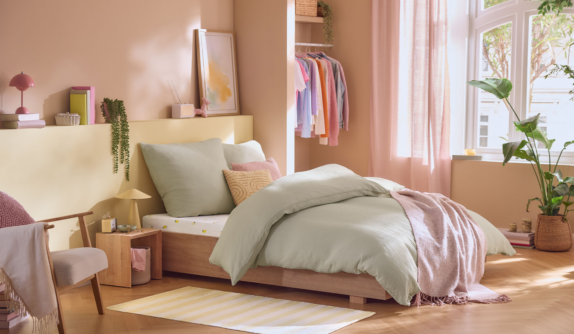 Chambre aux couleurs pastel avec un lit, une armoire et des plantes, de style scandinave.