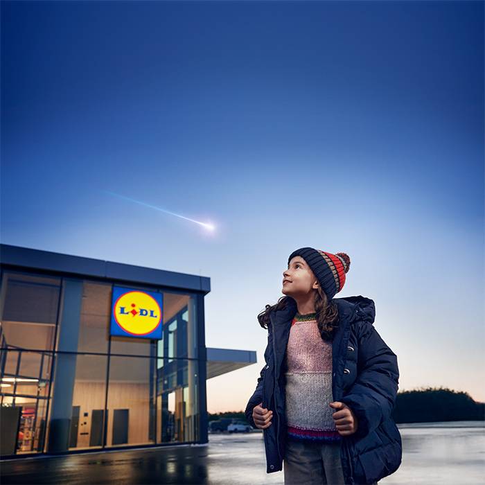 Une fille regarde une étoile filante au-dessus d'un magasin Lidl.